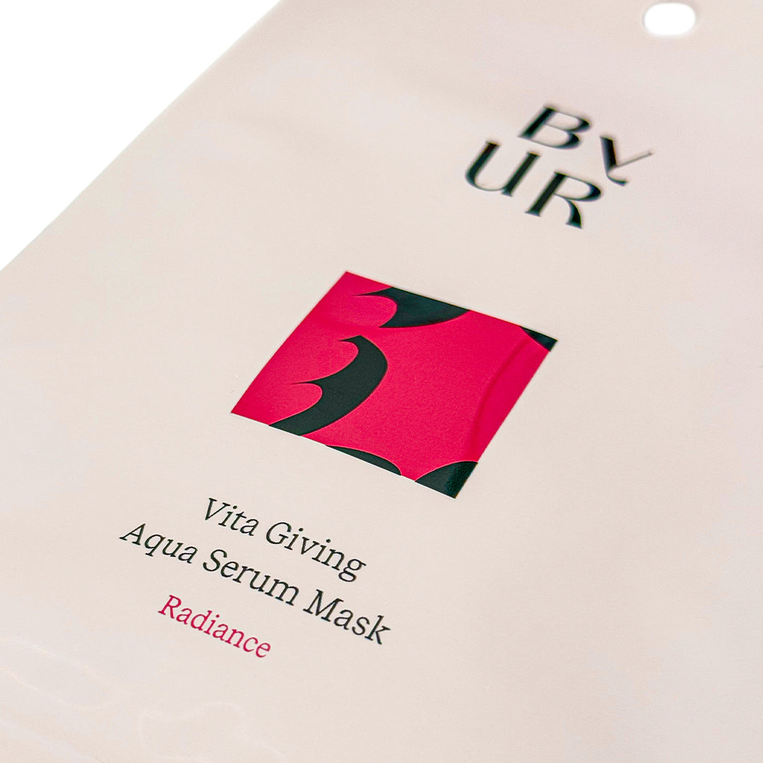 Close-up of a pink BYUR sheet mask packaging with text and branding.